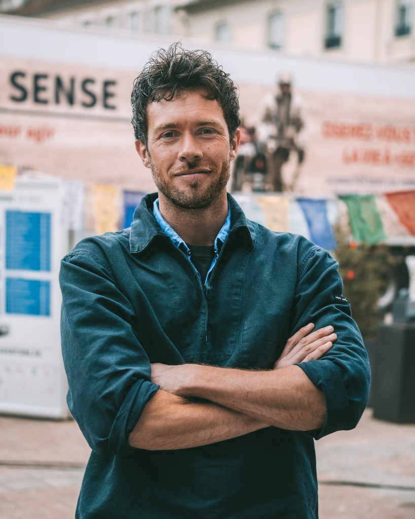 Pierre-Antoine Guillotel, aventurier, écrivain. Auteur du livre Island, aux éditions Transboréal. Homme debout, bras croisé, avec sourire.